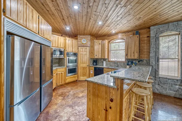 a kitchen with granite countertop a refrigerator and a stove