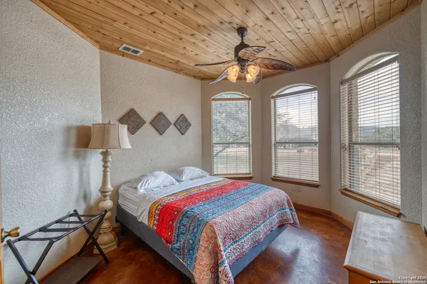 a bedroom with a bed and a ceiling fan