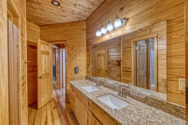a view of spacious bedroom with a bed and wooden floor