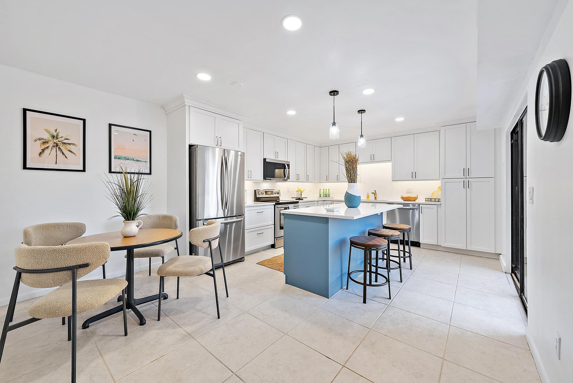 1420 Ocean Way, Unit 30C Jupiter, FL 33477 - Photo 1 of 25 a kitchen with a dining table chairs and refrigerator