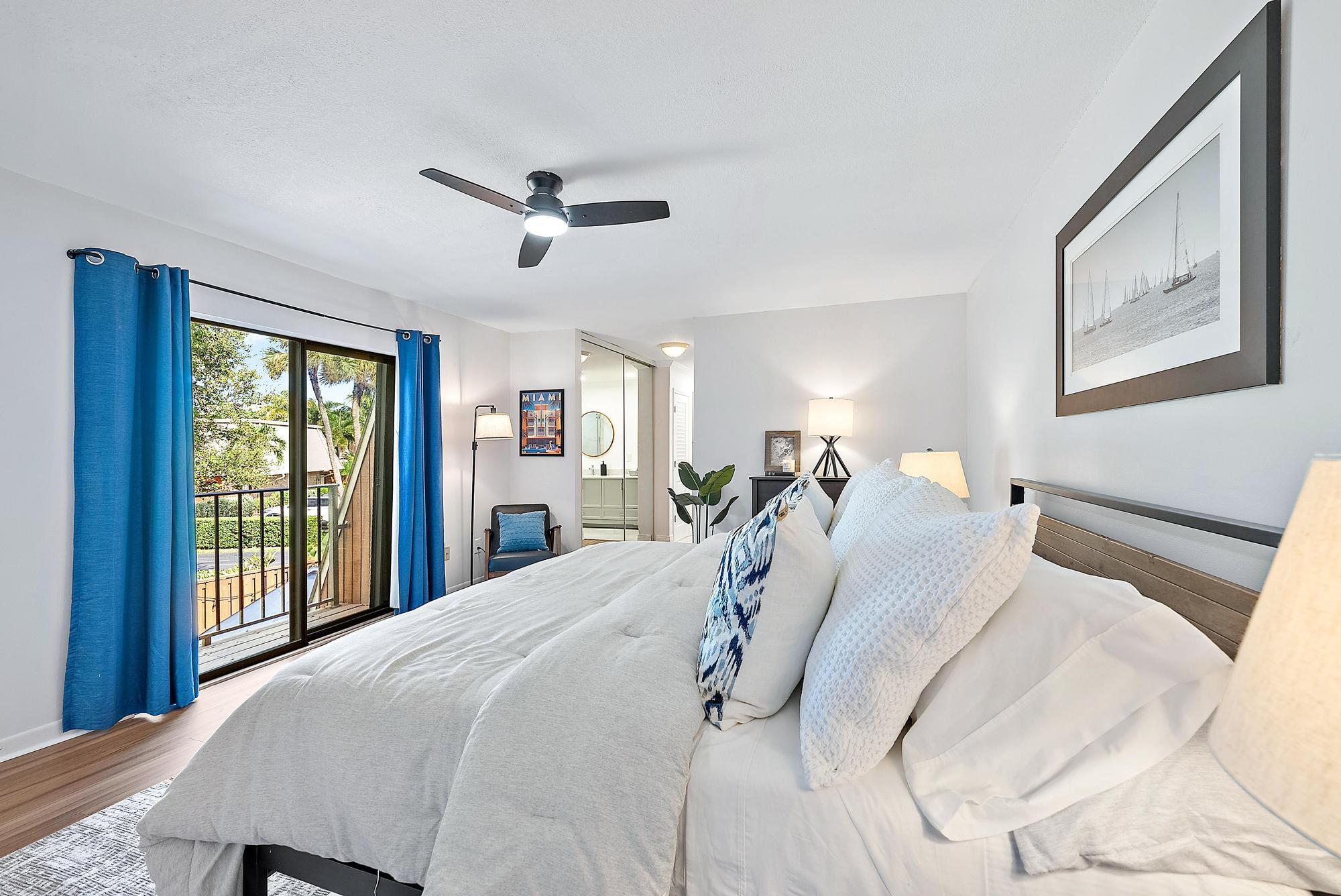 1420 Ocean Way, Unit 30C Jupiter, FL 33477 - Photo 14 of 25 a bed room with a bed and a chandelier