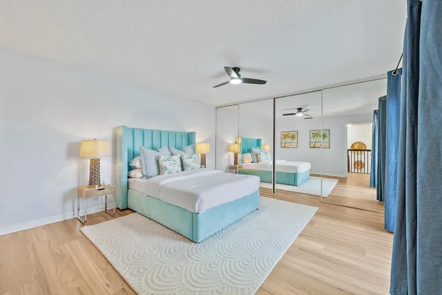 a spacious bedroom with a bed a mirror and lamp