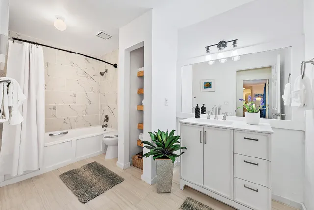 a bathroom with a shower sink vanity mirror and bathtub