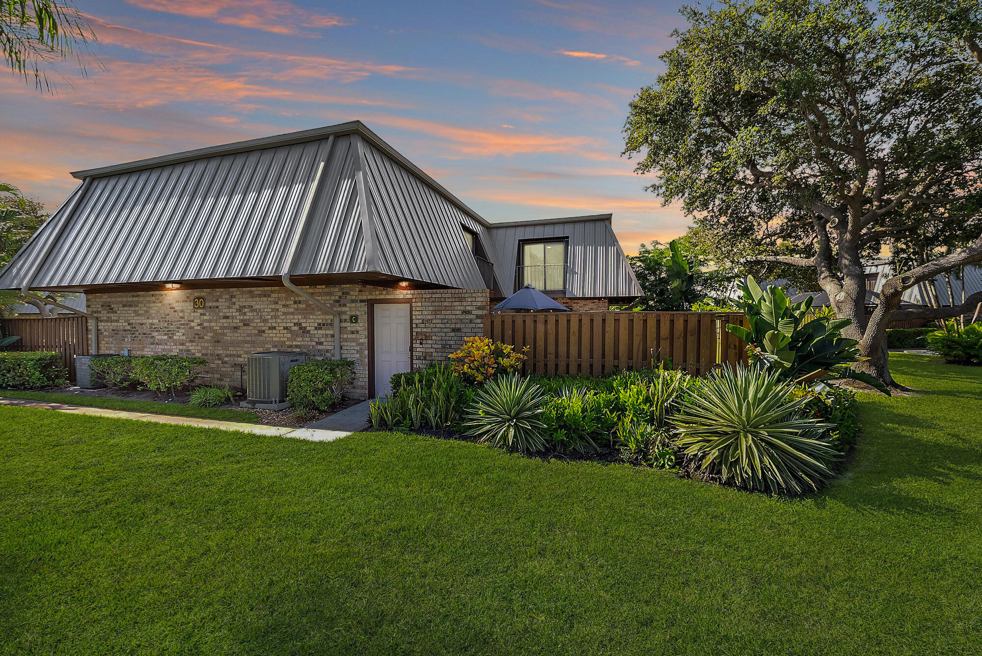 1420 Ocean Way, Unit 30C Jupiter, FL 33477 - Photo 3 of 25 a front view of a house with garden