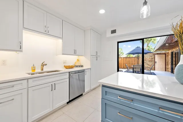 a kitchen with granite countertop white cabinets and white appliances
