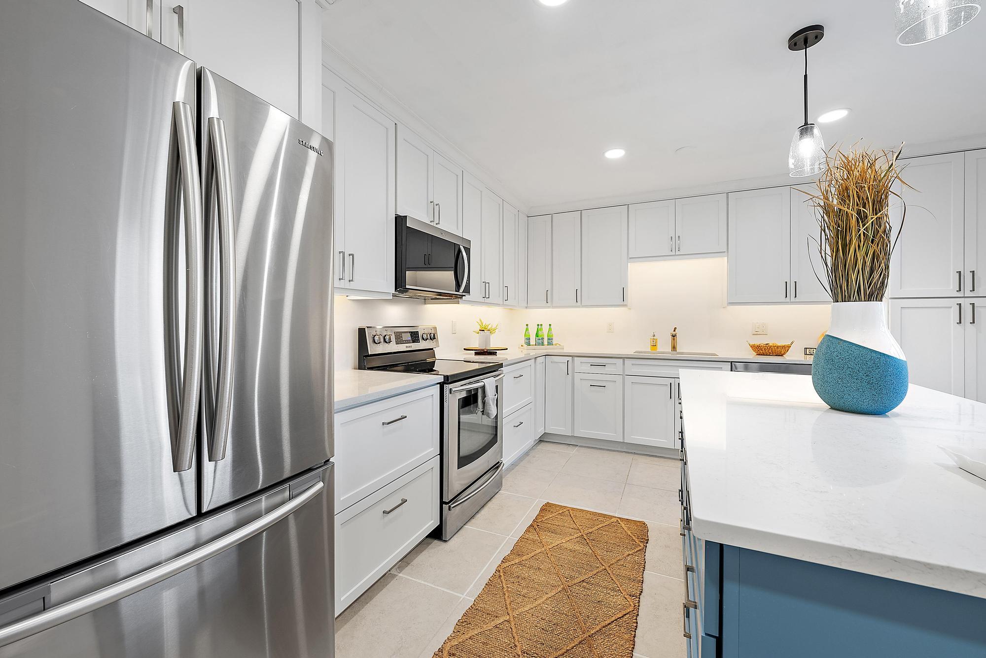 1420 Ocean Way, Unit 30C Jupiter, FL 33477 - Photo 8 of 25 a kitchen with a sink a counter top space stainless steel appliances and cabinets