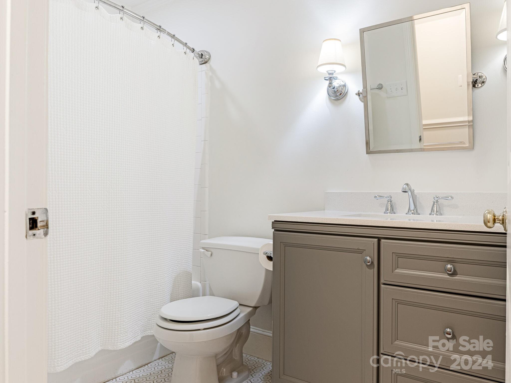3912 Lovett Circle Charlotte, NC 28210 - Photo 19 of 25 a bathroom with a toilet sink and mirror