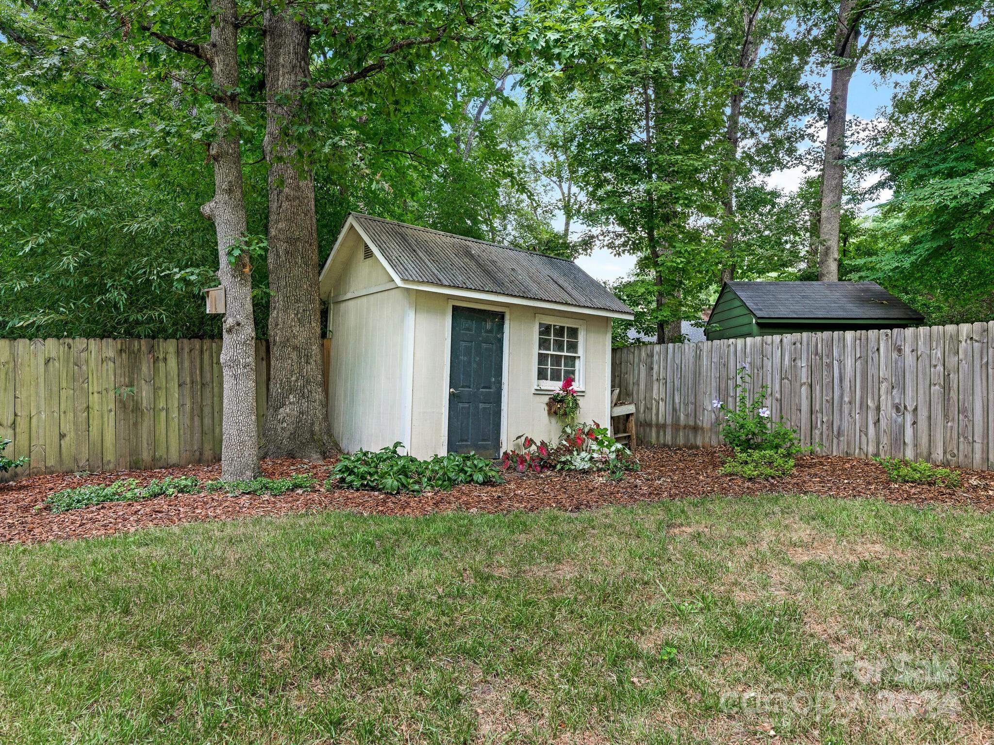 3912 Lovett Circle Charlotte, NC 28210 - Photo 24 of 25 a backyard of a house with table and chairs and a large tree