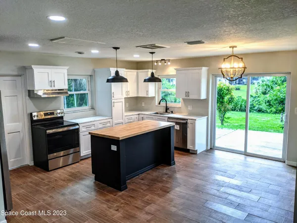 a kitchen with stainless steel appliances granite countertop a stove a sink and a refrigerator