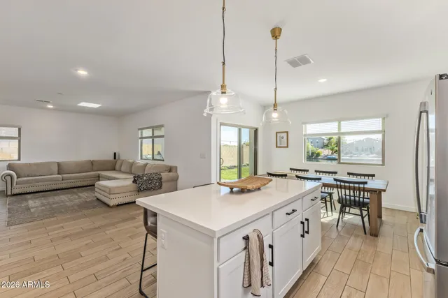 a large kitchen with a table chairs refrigerator and furniture