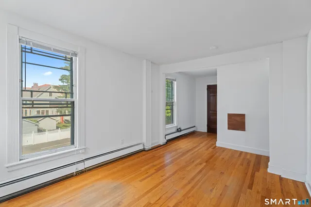 a view of a room with wooden floor and a window