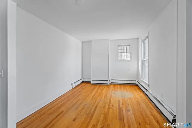 a view of a room with wooden floor and window