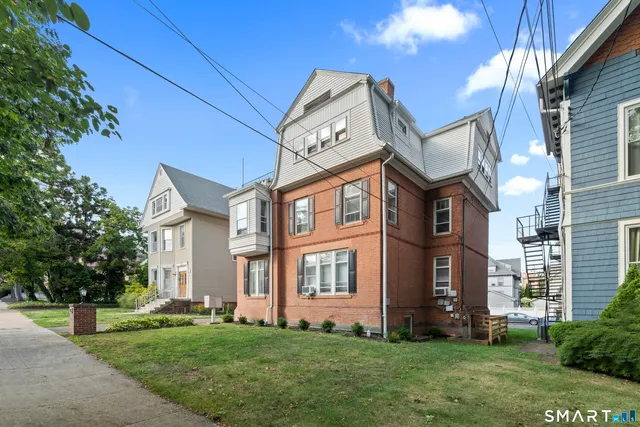 a front view of a residential apartment building with a yard