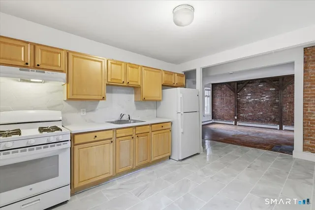 a kitchen with a refrigerator and white cabinets