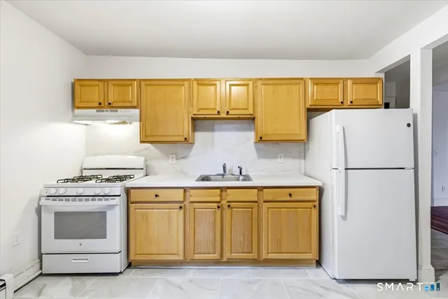 a kitchen with a stove a refrigerator and a sink