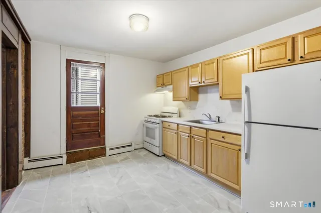 a kitchen with cabinets a refrigerator and a sink
