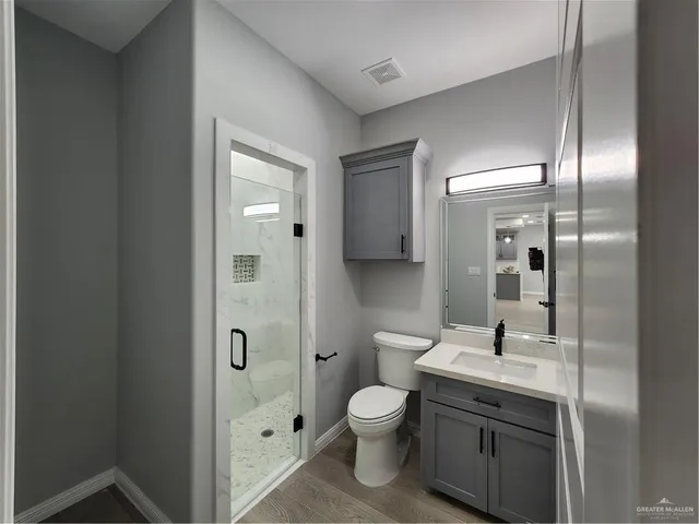 a bathroom with a toilet a sink and mirror