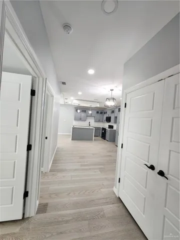 a view of a hallway with wooden floor