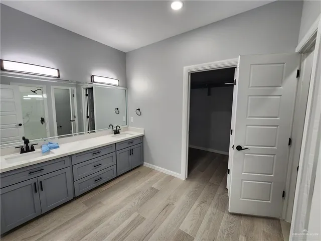 a large bathroom with a double vanity sink a large mirror and a shower