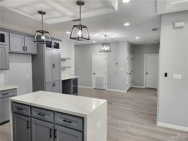 a kitchen with kitchen island stainless steel appliances sink cabinets and wooden floor