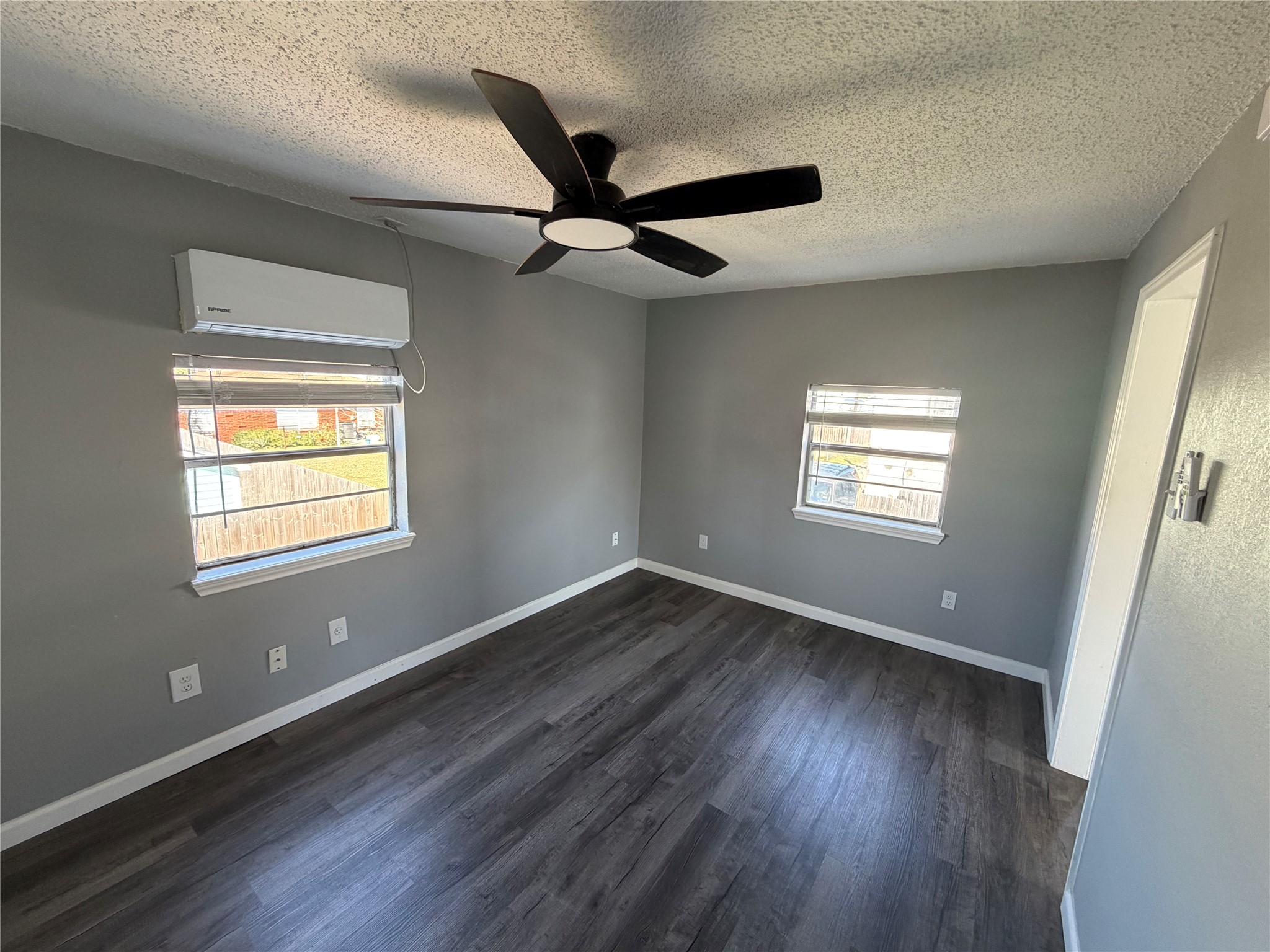 5616 Avenue R, Unit 2 Galveston, TX 77551 - Photo 1 of 8 a view of an empty room with wooden floor and a window
