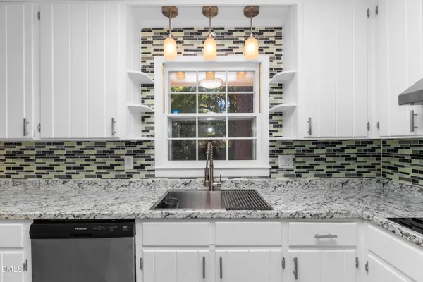 a kitchen with granite countertop appliances a sink cabinets and wooden floor