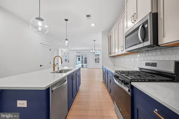 a kitchen with stainless steel appliances granite countertop a sink a stove oven a counter top space and cabinets