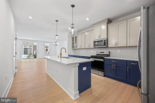 a kitchen with kitchen island granite countertop a sink counter top space appliances and cabinets