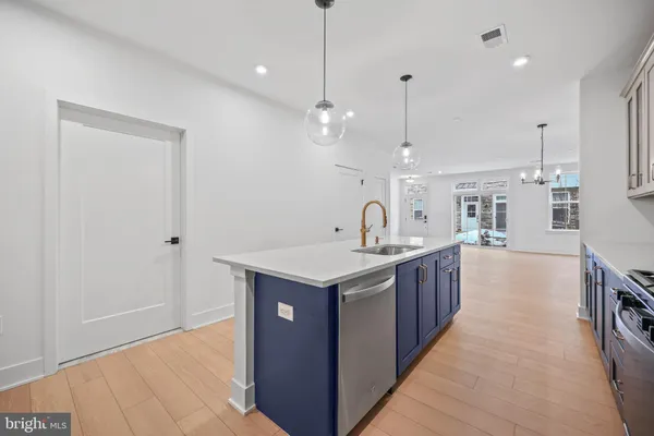 a kitchen with a stove sink and cabinets