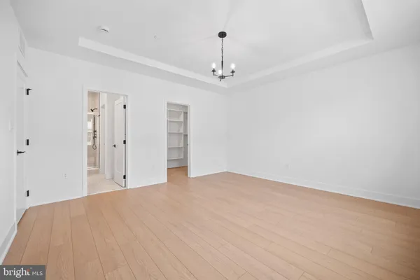 a spacious bedroom with a large bed and a chandelier