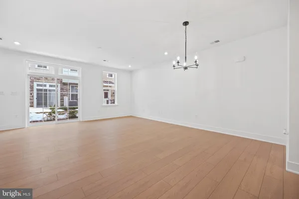 a view of a livingroom with wooden floor and a ceiling fan