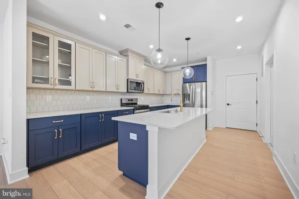 a large kitchen with kitchen island a sink a stove a center island a stove and a window