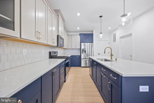 a kitchen with stainless steel appliances a sink stove and cabinets