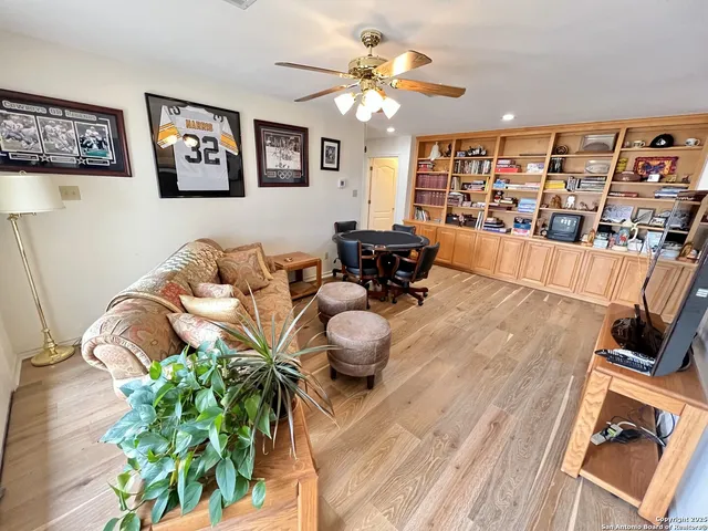 a living room with furniture flowerpot and wooden floor
