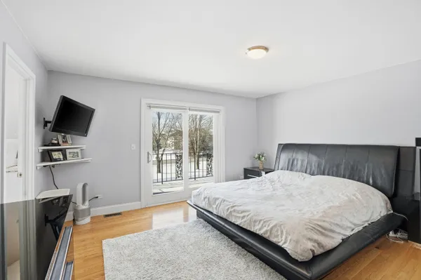 a bedroom with a bed flat screen tv and windows