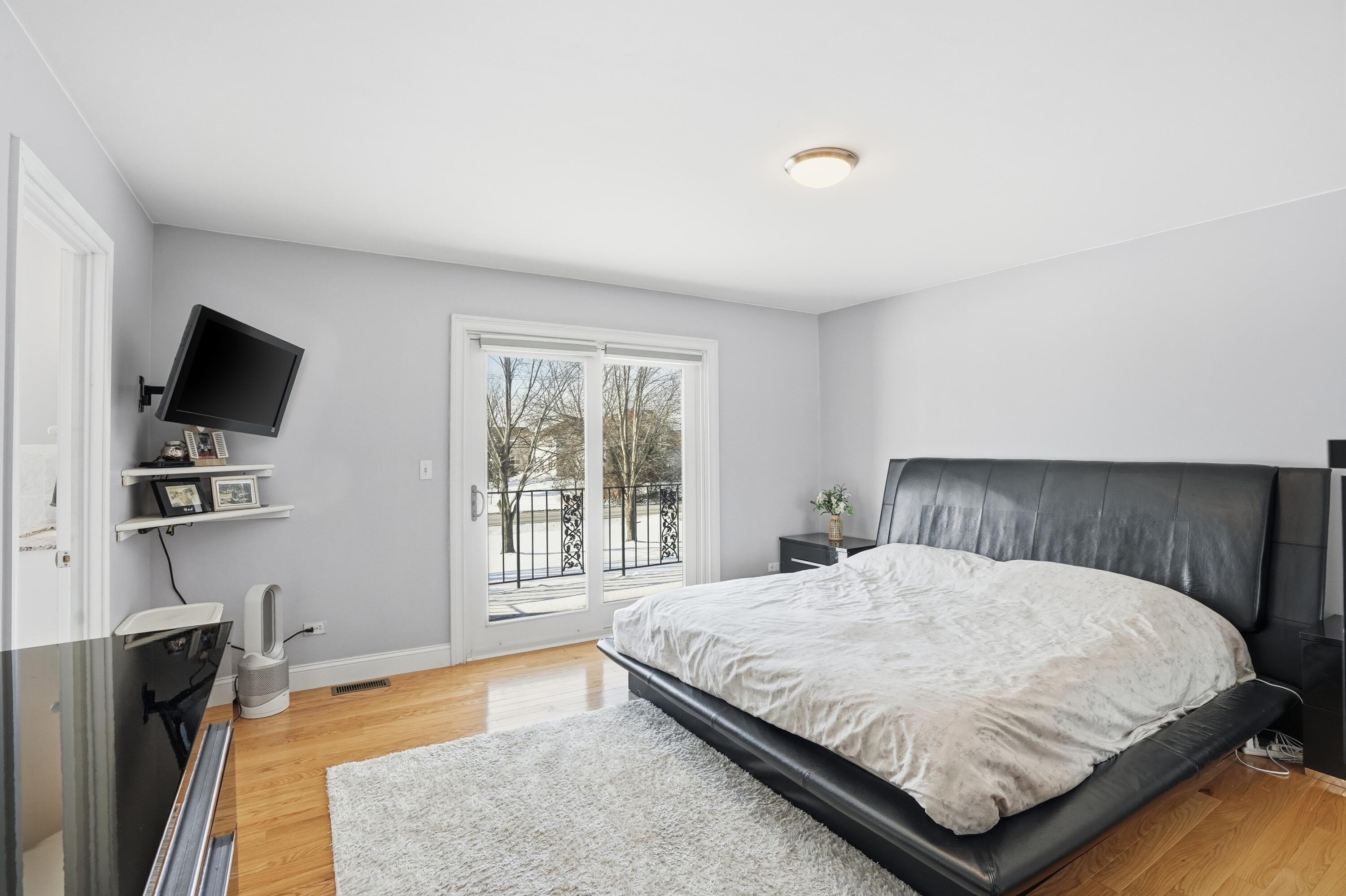 11109 Iowa Street Crown Point, IN 46307 - Photo 12 of 31 a bedroom with a bed flat screen tv and windows