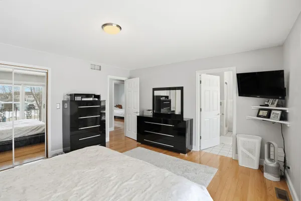 a bedroom with a bed and a flat tv screen on a dresser