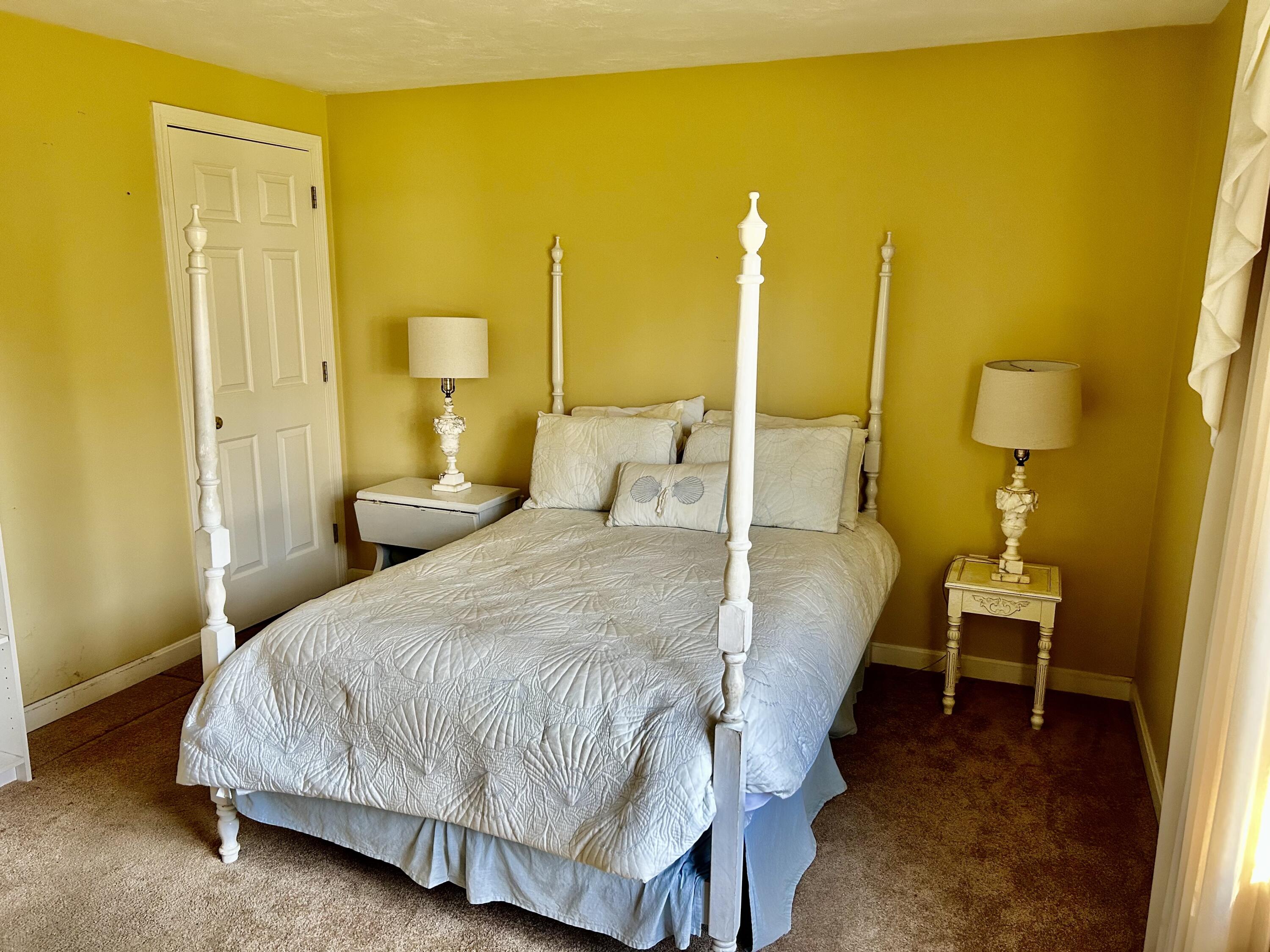28 Windward Street, Unit 28 Mashpee, MA 02649 - Photo 9 of 37 a bedroom with a bed and chandelier