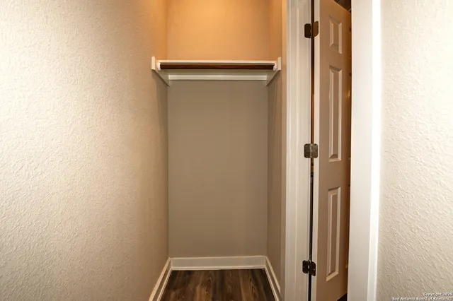 a view of walk in closet with empty racks