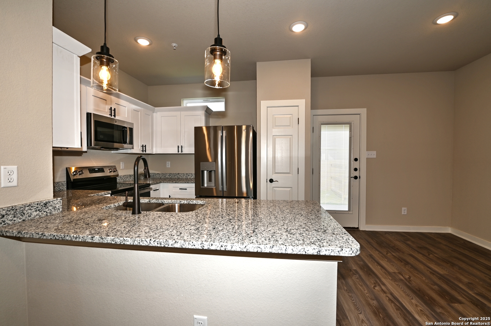 11318 Clearmine, Unit 101 San Antonio, TX 78224 - Photo 13 of 39 a kitchen with stainless steel appliances granite countertop a sink refrigerator and microwave