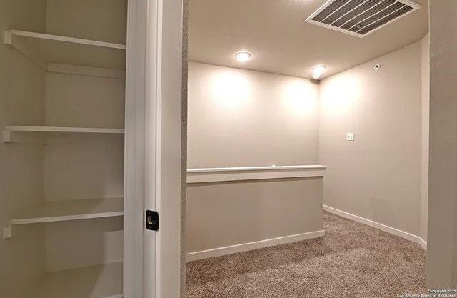 an empty room with closet and a ceiling fan