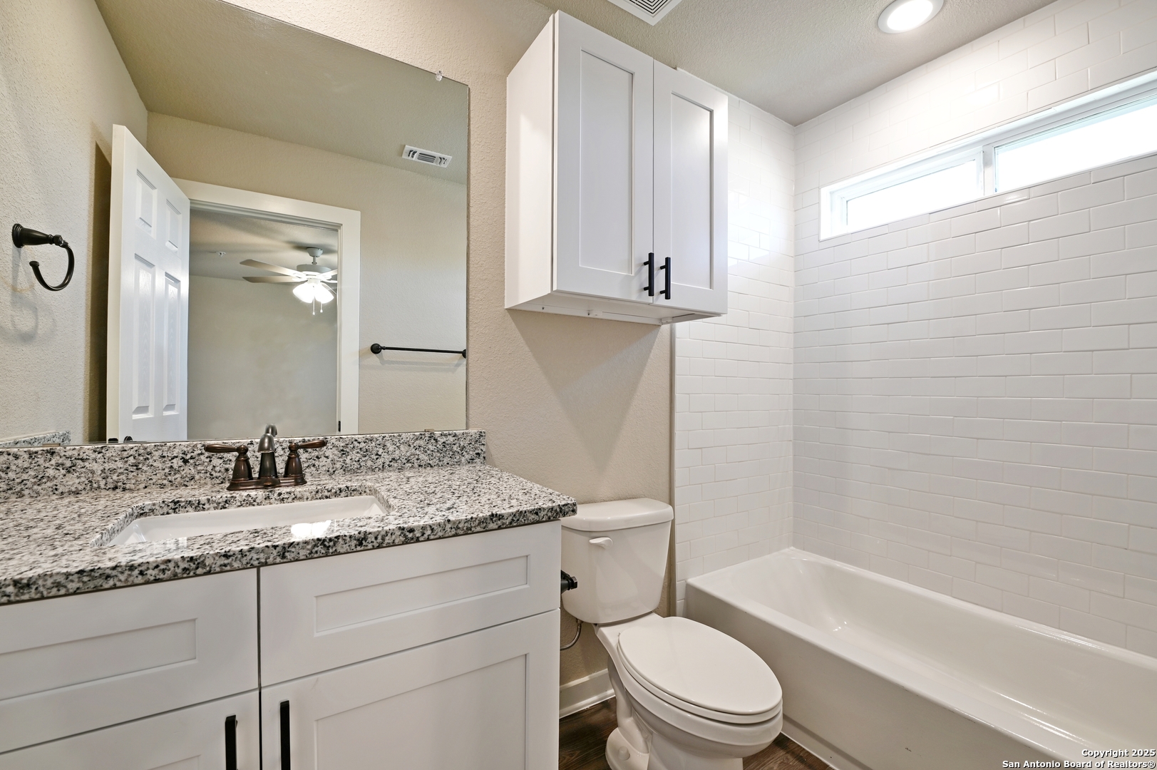 11318 Clearmine, Unit 101 San Antonio, TX 78224 - Photo 29 of 39 a bathroom with a granite countertop toilet sink and mirror