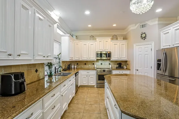 a kitchen with stainless steel appliances granite countertop a sink stove and refrigerator