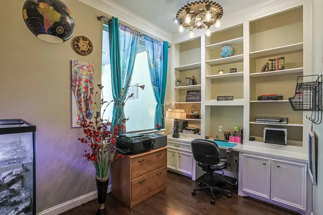 a view of a workspace with furniture and a window