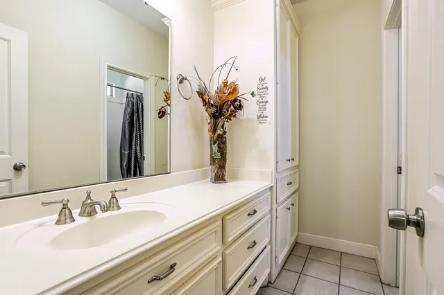 a bathroom with a granite countertop sink a mirror and a shower