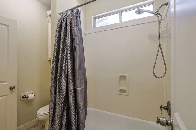 a bathroom with a shower a toilet and a sink