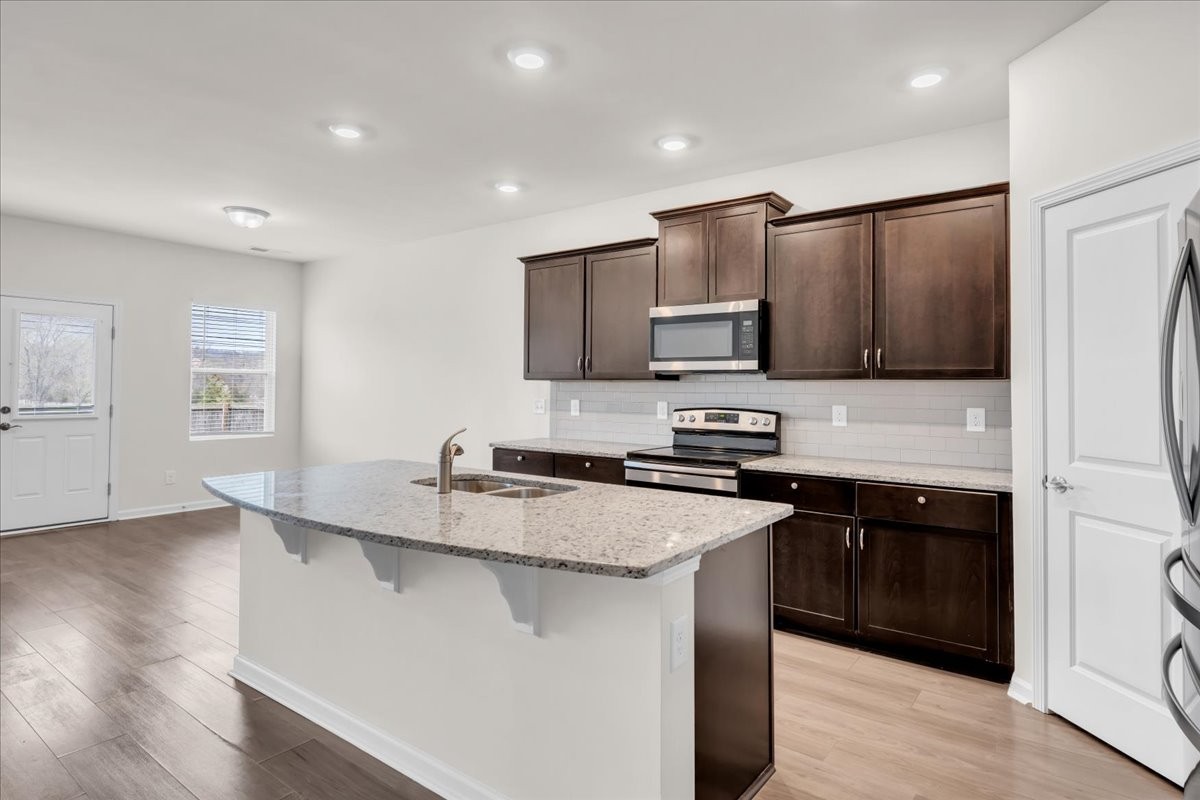 1846 Radnor Road Lebanon, TN 37087 - Photo 14 of 59 a kitchen with stainless steel appliances granite countertop a sink stove and refrigerator