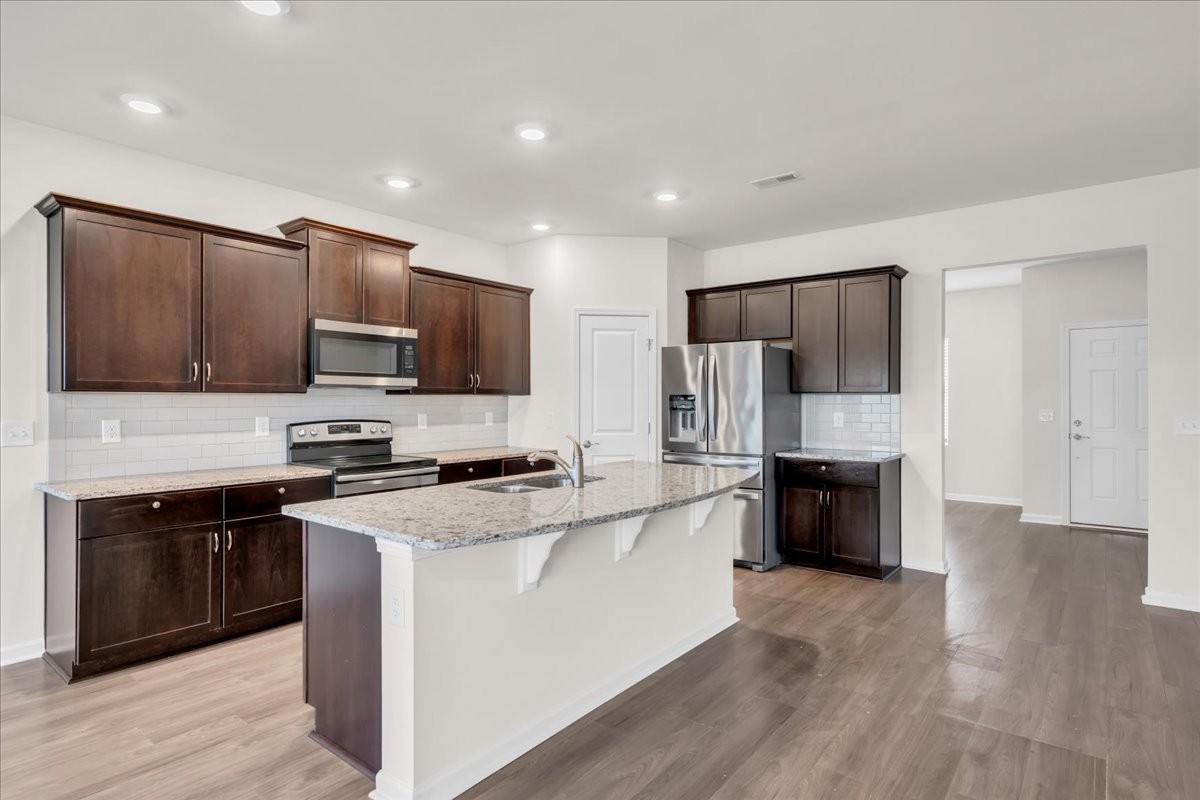 1846 Radnor Road Lebanon, TN 37087 - Photo 17 of 59 a kitchen with stainless steel appliances granite countertop a stove top oven a refrigerator a sink and dishwasher with wooden floor