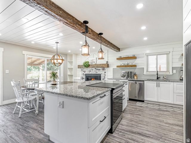 523 South Main Street Payson, UT 84651 - Photo 2 of 41 Kitchen featuring a central island with a built-in range, white cabinetry, granite countertops, and wood-finish flooring