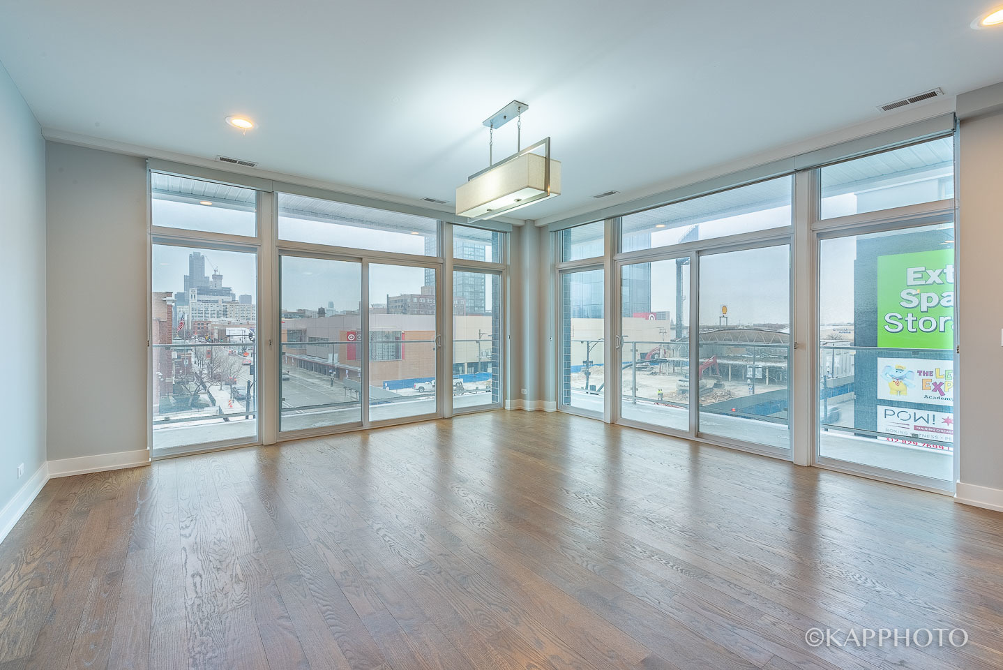 236 South Racine Avenue, Unit 401 Chicago, IL 60607 - Photo 8 of 24 a view of an empty room with wooden floor and a large window